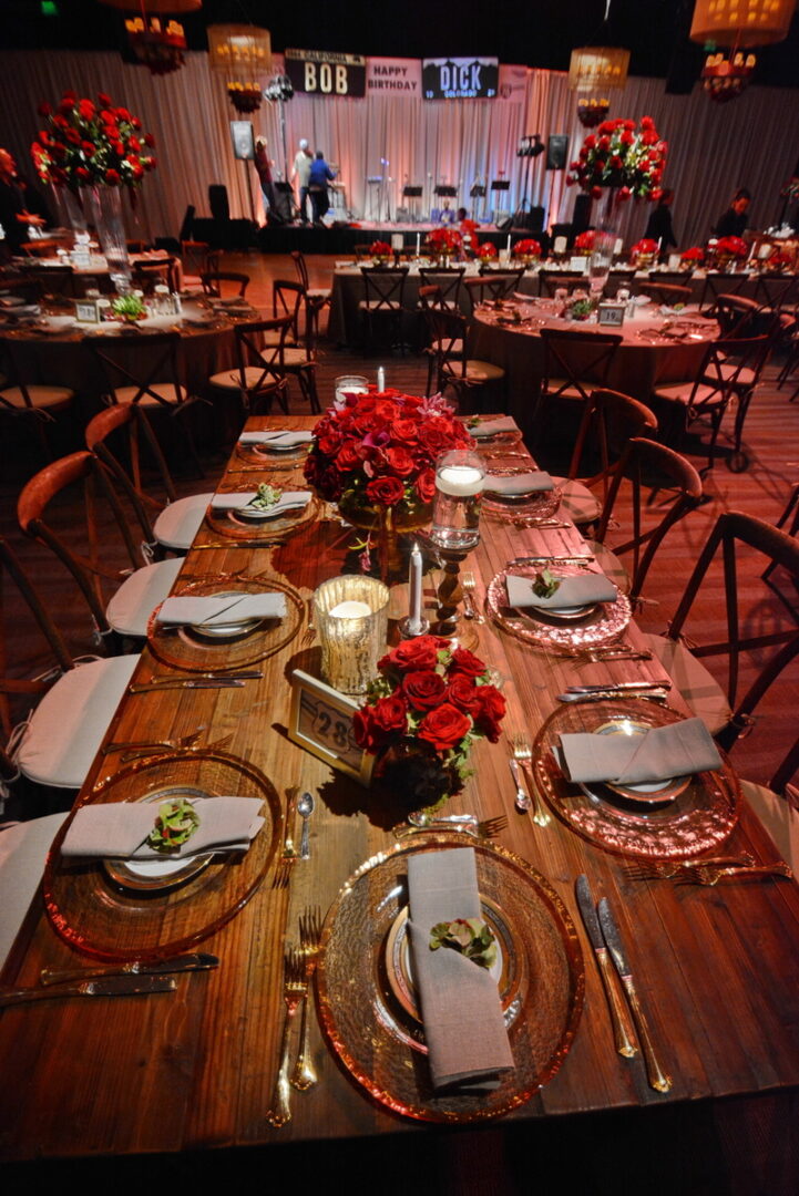 Banquet Wooden Table Decorated With Red Roses, Candles and Plates Are Placed on Table